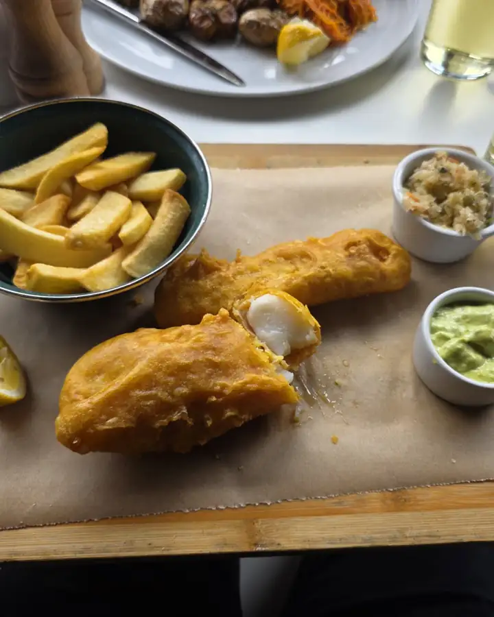 Fish & chips with sauce on a wooden board